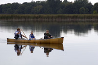 Three people in a canoe on the water.